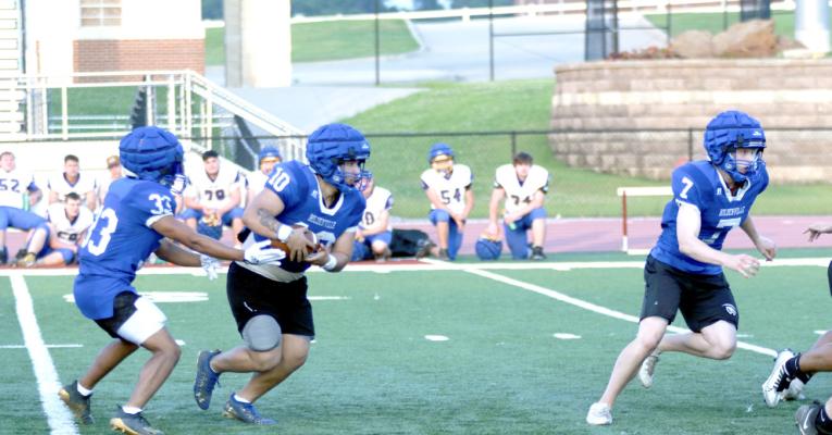 # 33,Malachi Henderson hands the ball to # 10 Julis Jackson while # 7 Gage Smith clears the way in the Wolverines’ team camp at Atoka. Wolverine head coach, David Barker, was pleased with his team’s overall performance at the camp.