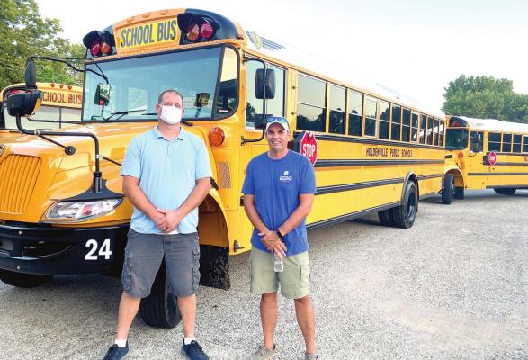NEW BUS INSPECTION – Holdenville Public Schools Board members Micah Mitchon and Kevin Arthur are shown inspecting the new buses that were recently purchased thanks to a voter-approved $360,000 bond. The members were impressed with the wider doors and higher ceilings inside, although the leg room wasn’t as much as they remembered from their school days.