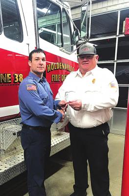 Fire Chief Shelton Fosters presents firefighter JD Conley with award for Bravery after he rescued fellow firefighter, Conner Brannon from beneath a ceiling that had collapsed inside of a burning house.