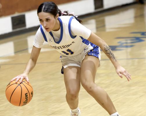 Holdenville’s Princess O’Neil shows off her ball handling skills as she dribbles around a Wewoka defender. Holdenville defeated the Tigers 55-34.