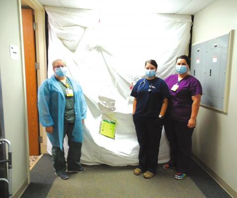 PROTECTIVE DIVIDER - As part of Holdenville General Hospital’s response to an increase in Covid-19 cases the north end of the acute care hallway has been restricted to COVID-19 patients. A temporary divided has been erected to isolate the area. Hospital personnel wear the appropriate personal protective equipment when they enter to provide patient care. Pictured are (left to right) Jolene Hardin, Kylie Davis, and Tierra Jinkins.
