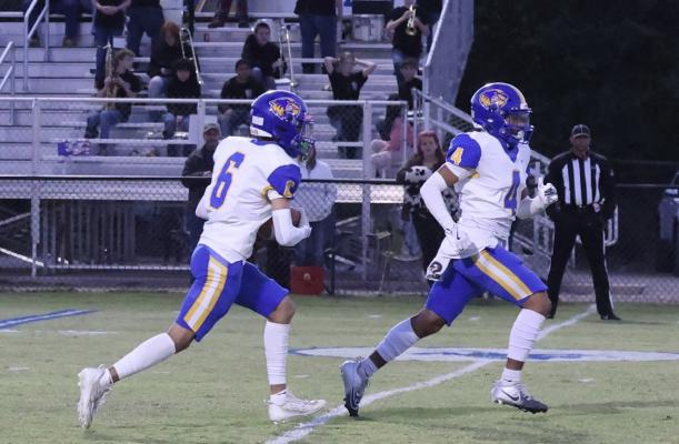 Holdenville kick-off return specialists, # 4, Mike Piza leads # 6, Kase Sipes on a kick-off return at Dibble. Holdenville won the game 38-20.