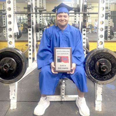STRENGTH AND SUCCESS — 2026 Holdenville graduate Aaron Torres poses in the HHS weight room with his Class 2A State Powerlifting Championship plaque, proving he carried more than just weights during his high school career. Torres leaves Holdenville as a state champion powerlifter and proud Wolverine senior. Some seniors leave behind memories. Aaron Torres leaves behind records, medals and a state championship title.