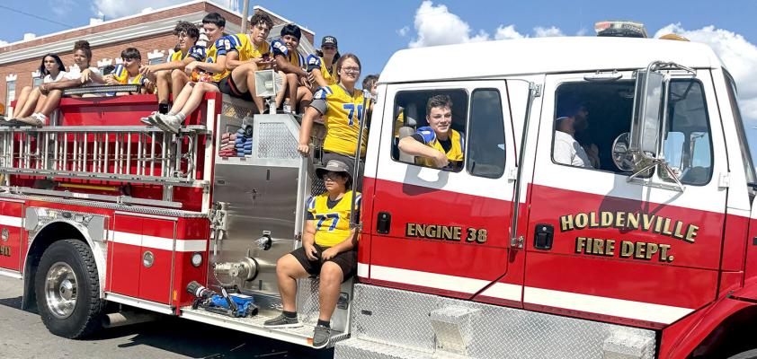 A TRADITION UNLIKE ANY OTHERS...Holdenville Fire Department leads the Homecoming Parade with the Holdenville Football Team on board.