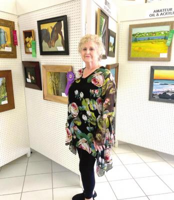 ART SHOW GREAT SUCCESS - Art Center Hostess Patsy Grove Law points out a small example of the outstanding entries in the 2020 Fall Art Show.