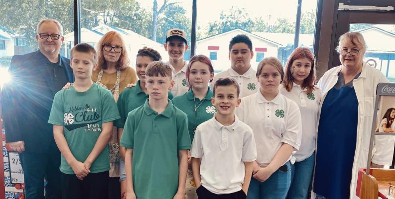 PICTURED ABOVE WITH SAVE-A-LOT STORE OWNERS AND MANAGERS ARE SOME OF THE HOLDENVILLE 4H CLUB. Pictured Front Row (L-R): Chris Remis, Boston Bowman, and Grayson Poulain. Middle Row: Lainee Yates, Bailey Sisco, and Saraphina Shady. Back Row: District Manager Kevin Nolen, Store Owner Linda Gibbs, Landen Yates, Jared Soria, Emma Johnson, and Store Manager Angela Gibbs.