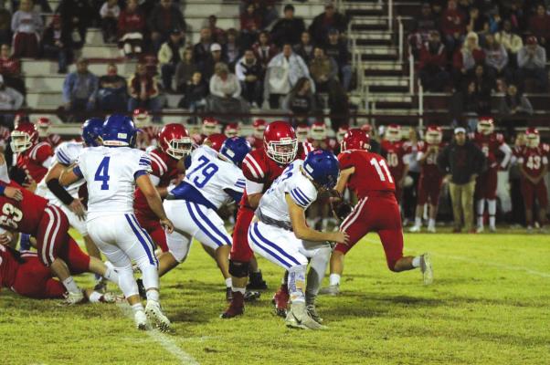 Holdenville defenders # 4, Christian Zambrano, # 82 Rylan Smith and # 79 Albert Fixico fight off blockers in order to tackle a Davis running back. The Wolverines stopped the Wolves from making a gain on the play.