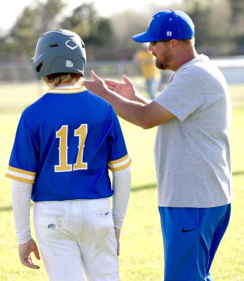 Moss baseball coach, Troy Miller, gives instructions to Konner Love in last week’s clash between the young Jr High Pirates and young Wolverines.