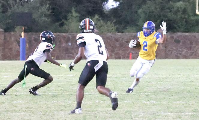 Holdenville running back # 2, RJ Lowe, cuts away from two Tiger defenders in the Wolverines’ 62-20 victory over the Wewoka Tigers
