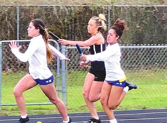 Blakeli Whiteman passes the baton to Samantha Eckles in the Wolverines’ 4x100 relay race. Holdenville won first place in the event.