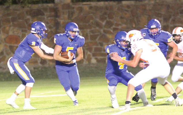 Holdenville running back # 5, Cy Tiger, takes a hand-off from Wolverine quarterback # 2, Matt Cox while # 4, Christian Zambrano and # 55 Cory Skeen clear the way. Holdenville defeated Lexington in the contest 16-8.