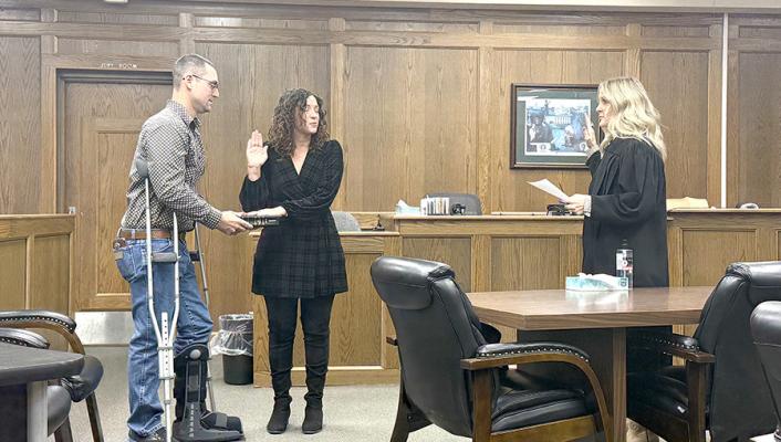 Brooke McNaughten, pictured above with husband Dylan, is sworn in by Judge Trisha Smith as Hughes County Assessor.