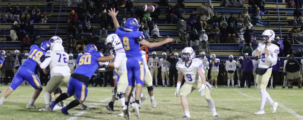 Holdenville defender # 9, Cash Carter, jumps high to deflect a Community Christian pass in the first quarter of the Wolverines’ game with the Royals. Holdenville defensive linemen, # 19 Clinton Roland and # 60 Kody Giles provide an extra defensive push.