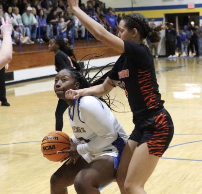 Holdenville’s Myah Olden, prepares to shoot the ball while this Wewoka defender attempts to hold her down with her right arm. No foul was called but Myah scored the basket anyway.