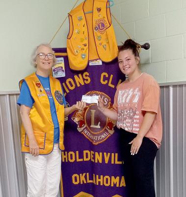 Lion Jerrie Lindsey presenting Hailey Cox her scholarship check from the Holdenville Lions Club. Hailey is attending Seminole State College to get her basics. The she will continue to pursue a degree in education.