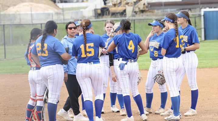 Holdenville Softball Coach, Angel Johnson, huddles with her Wolverine Softball Team during the Wolverines victory over Morris. Holdenville defeated the Eagles 9-8.