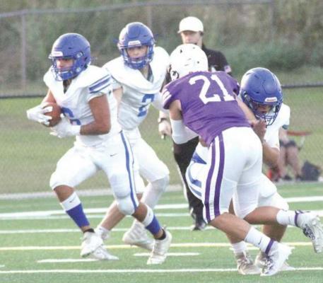Holdenville quarterback # 2 , Matt Cox, hands the ball to Wolverine running back # 6 Devon Tiger, while # 4, Christian Zambrano, blocks a Community Christian defender. Holdenville will host the Lexington Bulldogs this Friday for their second district game of the season.
