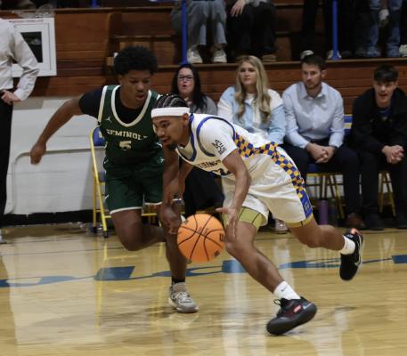 Holdenville guard, Mike Piza, smiles as he drives around a Seminole defender. Mike scored 12 points in the Wolverines’ home opener victory.
