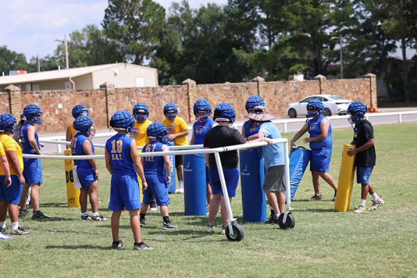 The Holdenville High School linemen gather around Wolverine head coach, David Barker, during a hot August preseason practice. The Wolverines will travel to Antlers on Thursday for the first scrimmage of the season.