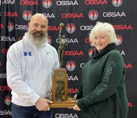 Ann Daugherty represented her cousin legendary Holdenville Wolverine basketball coach John Daugherty, at the ceremony commemorating Coach Daugherty’s 1942 basketball state championship team. Ann Daughterty and Holdenville athletic director Darin Johnson are shown holding the 1942 state trophy.