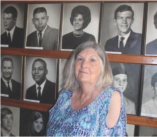 LINDA ROGERS, HHS CLASS OF 1967 is pictured standing in front of her Wolverine Sports Hall of Fame picture taken during the alumni reunion last year. This year the Class of 1973 will meet at Pallmer Inn on June 24 at 6:00. The 1950’s classes will all be held at the HSPS Art Center June 24 from 12:00 - 4:00 with several others meeting around the county.