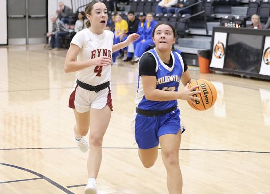 Holdenville guard Lexie Goolsby scoots by a Byng defender on her way to the basket. Holdenville will host Prague on Friday for the 2026 Homecoming Game.