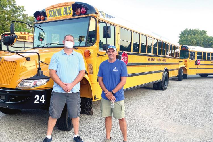 NEW BUS INSPECTION – Holdenville Public Schools Board members Micah Mitchon and Kevin Arthur are shown inspecting the new buses that were recently purchased thanks to a voter-approved $360,000 bond. The members were impressed with the wider doors and higher ceilings inside, although the leg room wasn’t as much as they remembered from their school days.