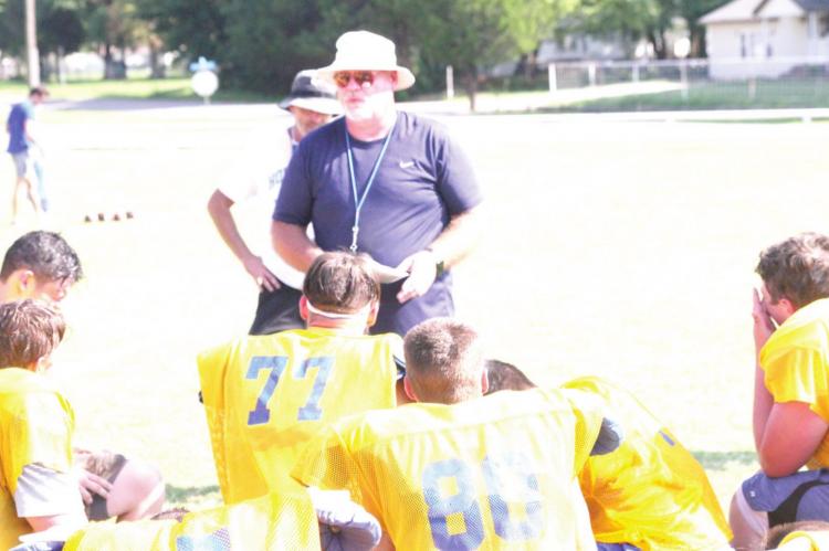 The Holdenville Wolverine football team gathered around head coach, Monte Lewis, after a hard, hot workout. Coach Lewis was quick to remind his squad to wear their face masks and avoid contacting the virus that caused the teams fi rst scrimmage to be canceled.