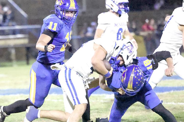 Holdenville defenders # 11 Tank Redmond and # 18 Landen Yates brought down this Hartshorne running back for a loss.