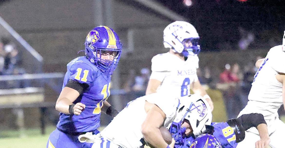 Holdenville defenders # 11 Tank Redmond and # 18 Landen Yates brought down this Hartshorne running back for a loss.